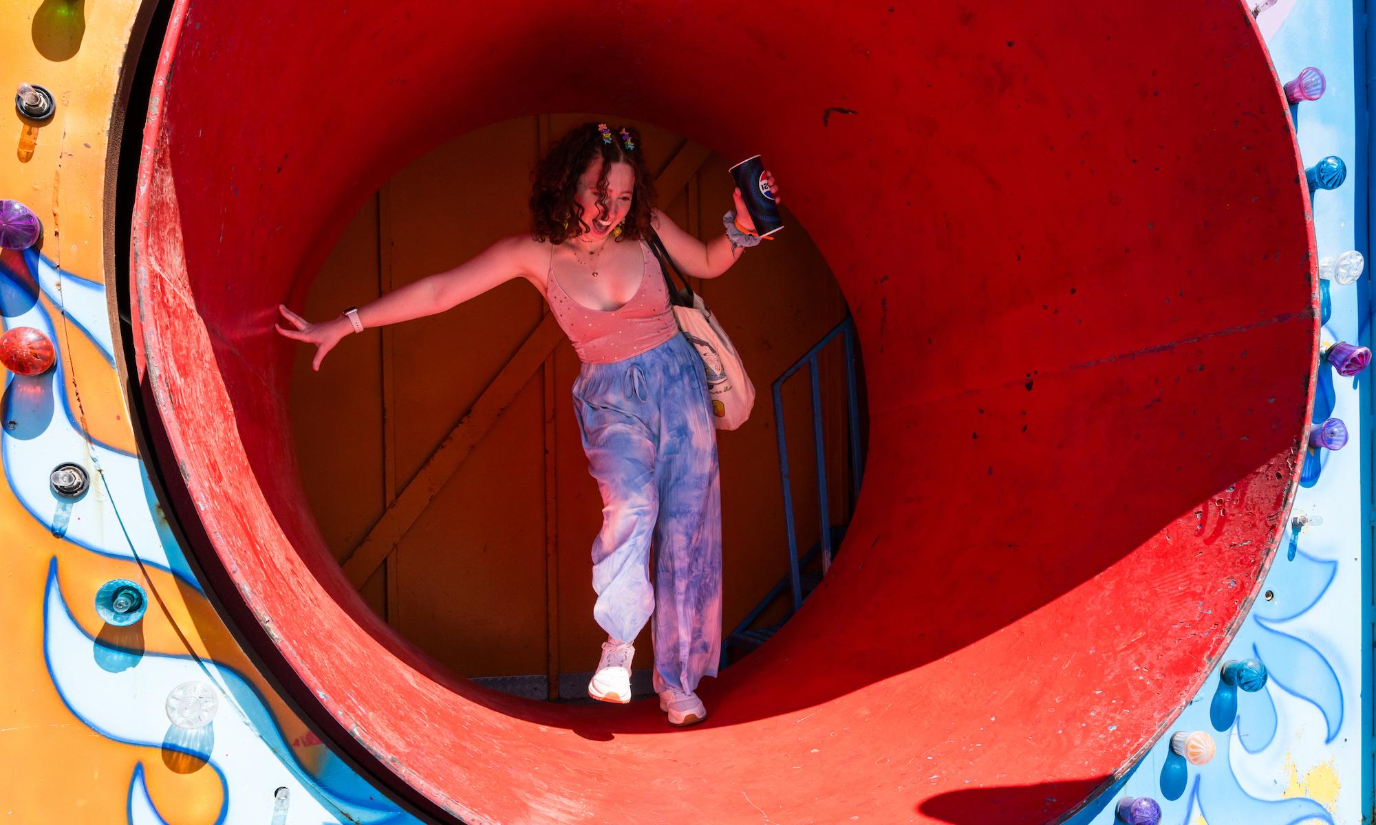 student emerges from rotating cylinder as part of a fun house