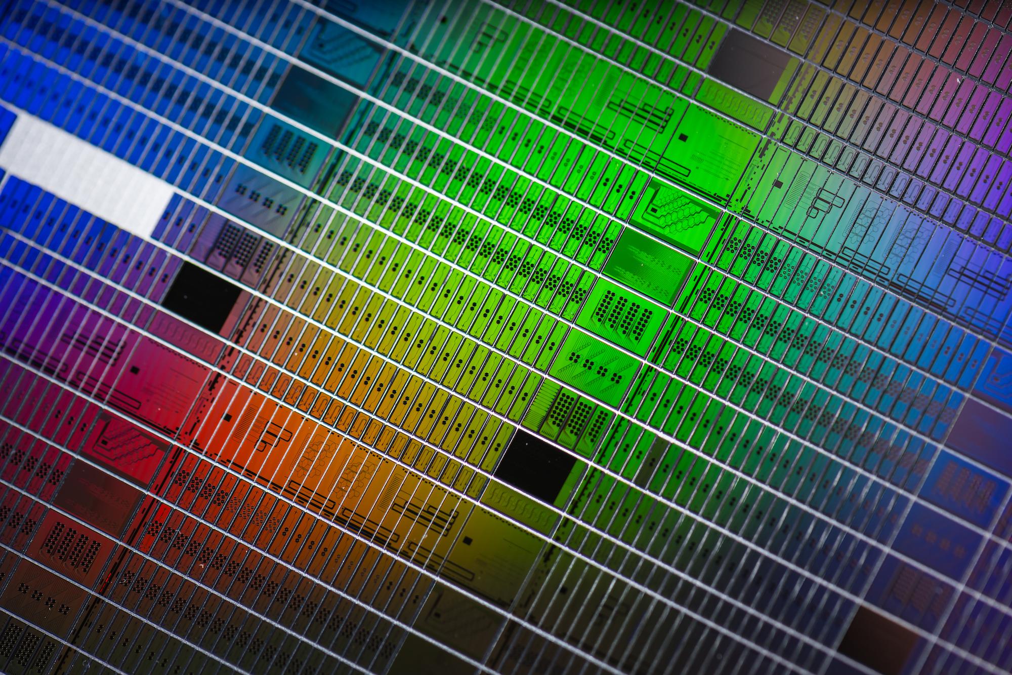 A photonic wafer with sensor chips under a rainbow spectrum of light